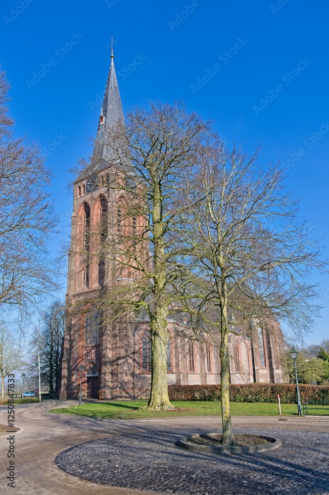 Sint Martinuskerk in the village of Baak in winter with a bare beech in the foreground. Sint Martinuskerk in the village of Baak in winter with a bare beech in the foreground.