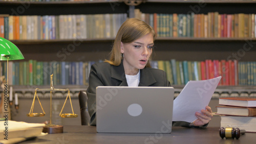 Upset Female Lawyer Doing Paperwork on Laptop in Office