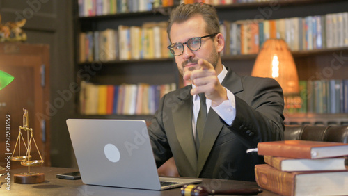 Middle Aged Lawyer Pointing at Camera with Laptop