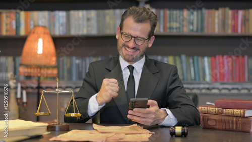 Middle Aged Lawyer Celebrating Success on Phone in Office