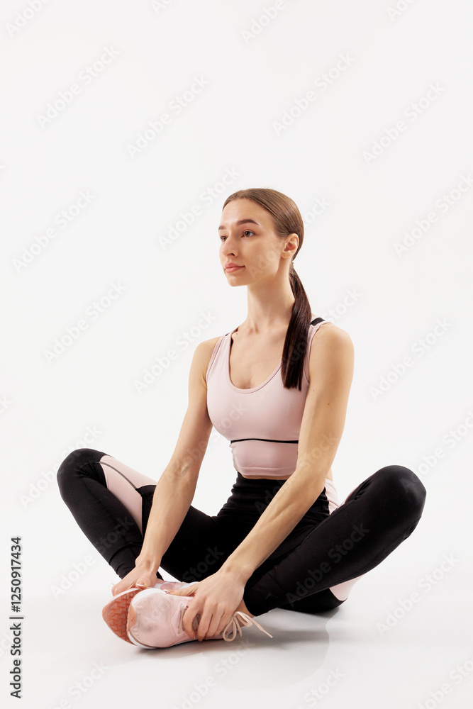 Woman stretching in a fitness studio during a morning workout session to maintain flexibility and enhance performance Woman stretching in a fitness studio during a morning workout session to maintain flexibility and enhance performance