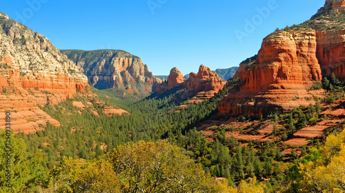 Scenic canyon landscape with red rock formations, valley greenery, bright blue sky in travel & tourism promotions and environmental awareness