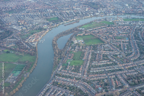 Obraz na płótnie Aerial view of London outskirts suburbs through early morning clouds with Thames river flowing at golden hour sunrise near industrial area w salonie