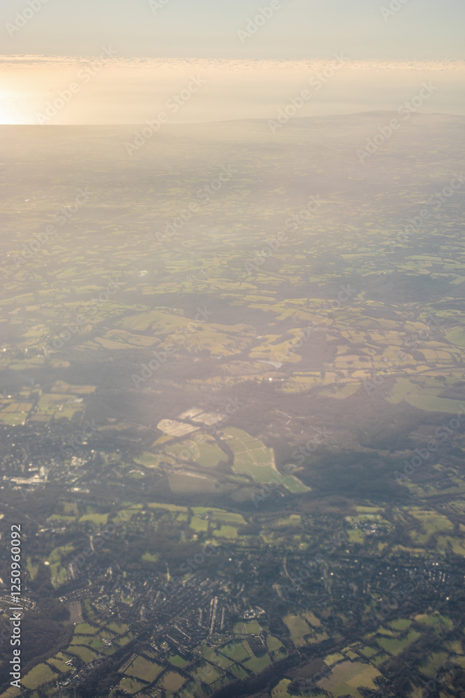 Aerial view of London outskirts lush green fields from an aeroplane window