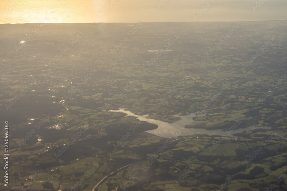 Aerial view of London outskirts lush green fields from an aeroplane window