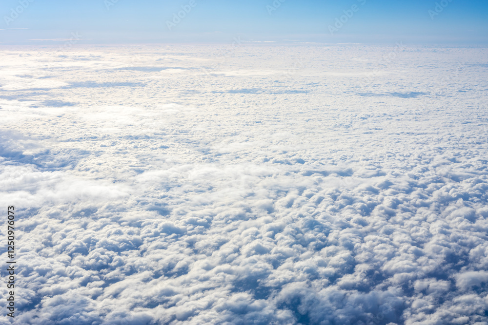 View of clouds from airplane window, clouds in a blue sky View of clouds from airplane window, clouds in a blue sky