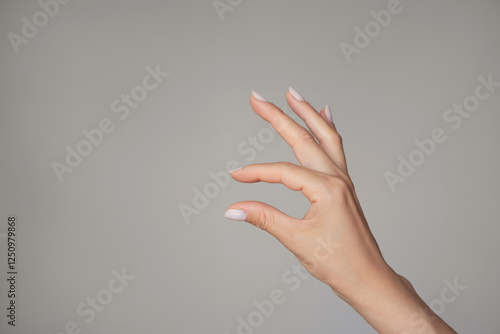 Foto A woman's hand holding something small with two fingers or showing small size