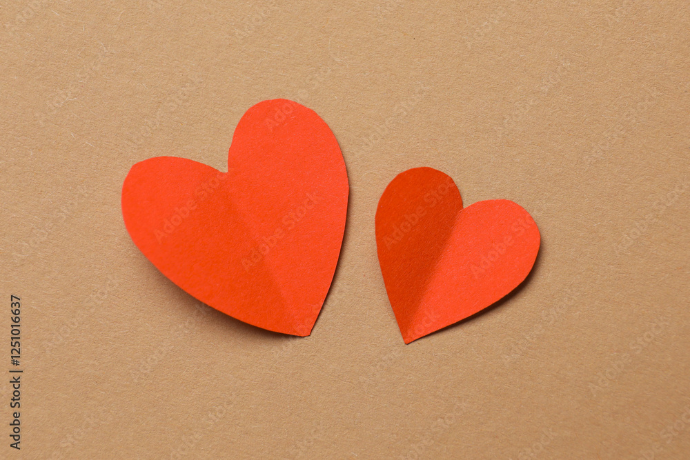 Fototapeta premium Valentine's Day. Paper hearts on brown background, top view
