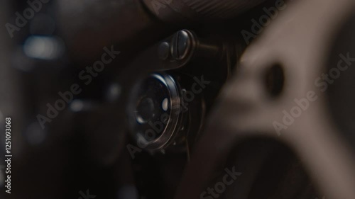 Close ups of a vintage 8MM projector spools moving and playing film 