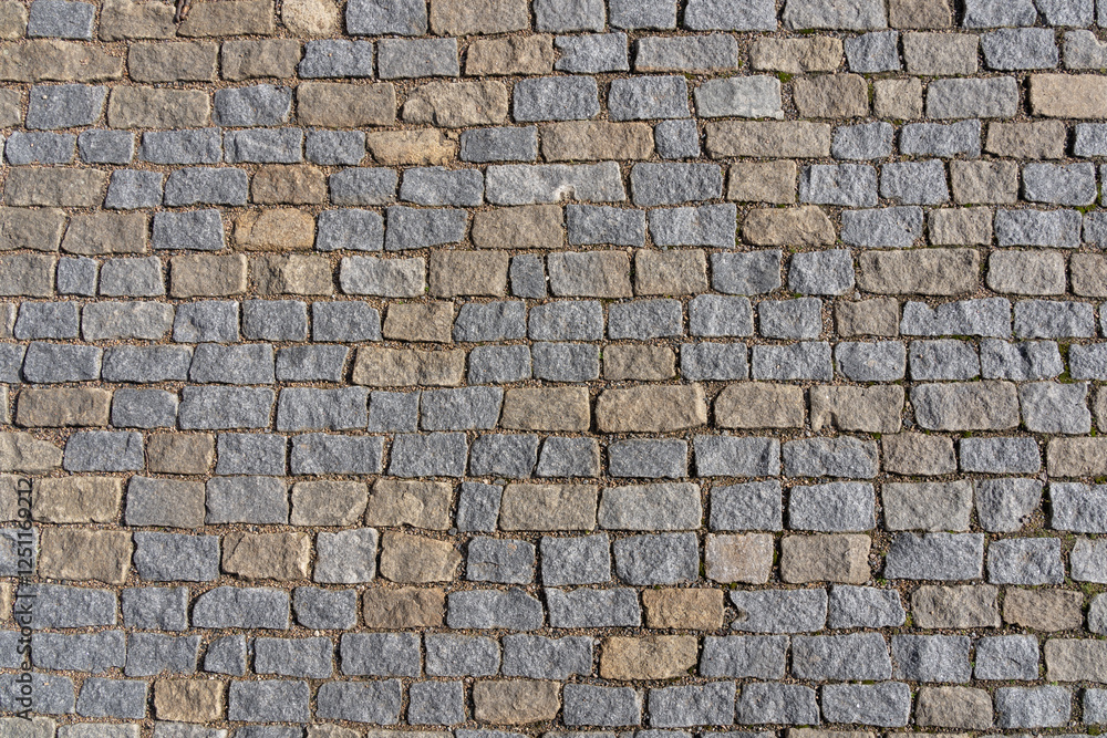 Cobblestone street with gray and beige paving stones - top view Cobblestone street with gray and beige paving stones - top view