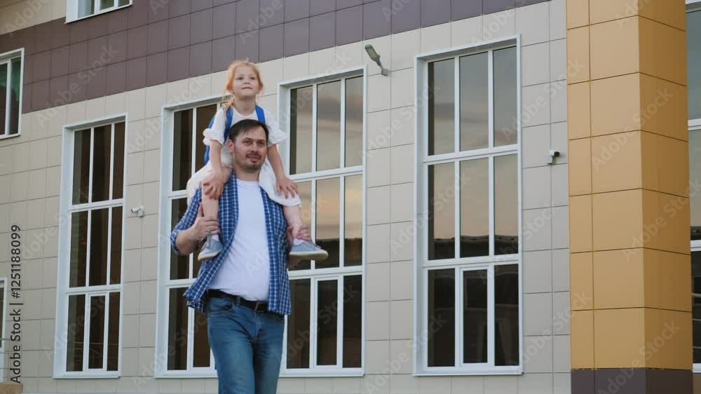 Happy father points forward carrying little girl on shoulders while going to school. Loving father takes little girl to school carrying daughter on shoulders. Girl and father go to school together Happy father points forward carrying little girl on shoulders while going to school. Loving father takes little girl to school carrying daughter on shoulders. Girl and father go to school together