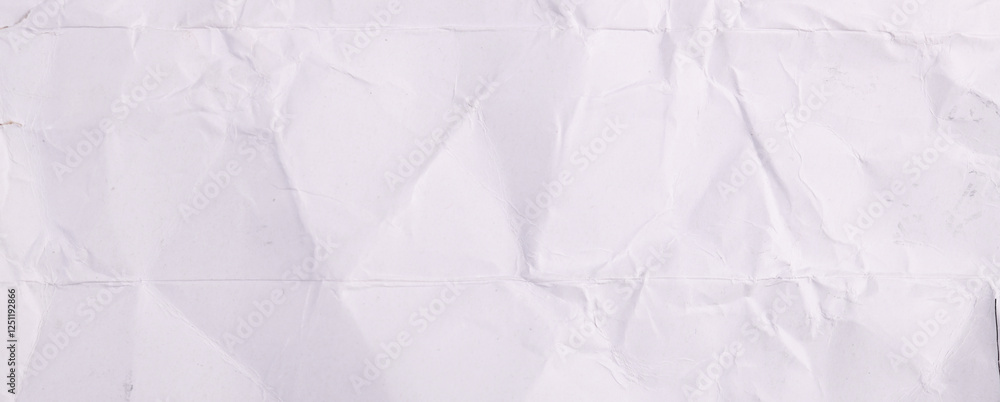 Obraz premium Crumpled paper texture highlighting irregular folds and shadows under soft lighting in an artistic layout.