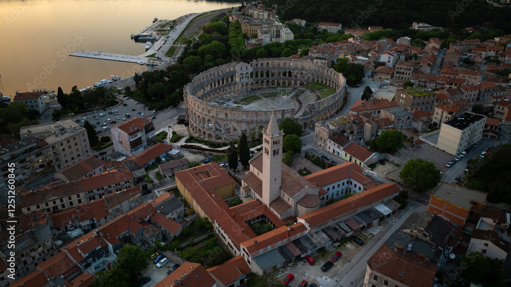 Fototapeta premium Flying above historic city of Pula , historic Roman amphitheatre of Pula aerial view, tourism in Croatia
