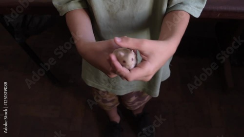 boy holding a rather restless hamster in his hands