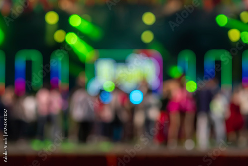 Blurred stage performance with colorful neon lights and dancing crowd