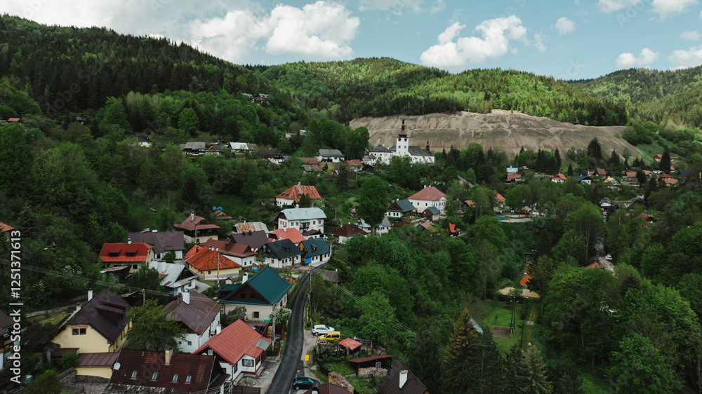 Fototapeta premium Beautiful aerial countryside landscape in Spania Dolina village, Slovakia. Old mining village. Historic church in Spania dolina. Summer rural lanscape in Slovakian mountains.