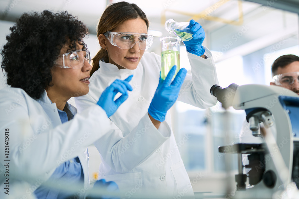 Two female scientists analyzing chemical substance in laboratory. Two female scientists analyzing chemical substance in laboratory.