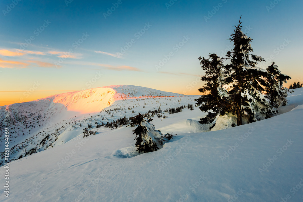 Giant Mountains in winter. Descent into the Krkonoše Mine at sunrise. Snow-covered trees on the mountains. Sunrise in the mountains Giant Mountains in winter. Descent into the Krkonoše Mine at sunrise. Snow-covered trees on the mountains. Sunrise in the mountains