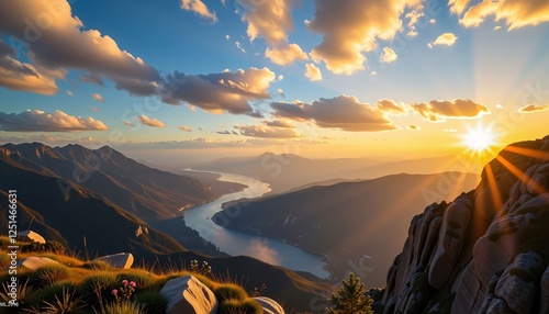 Golden sunrise over winding river in vast mountain valley with dramatic sky

