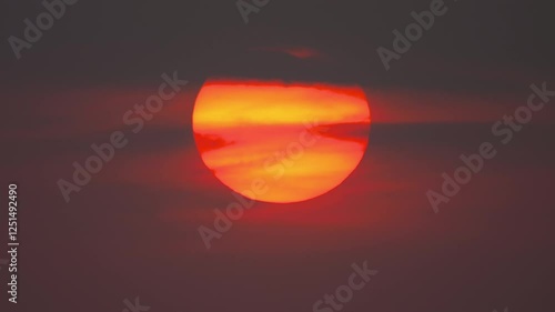 Timelapse of a big orange sun is going down by clouds. Scenic view of red sky, sunset