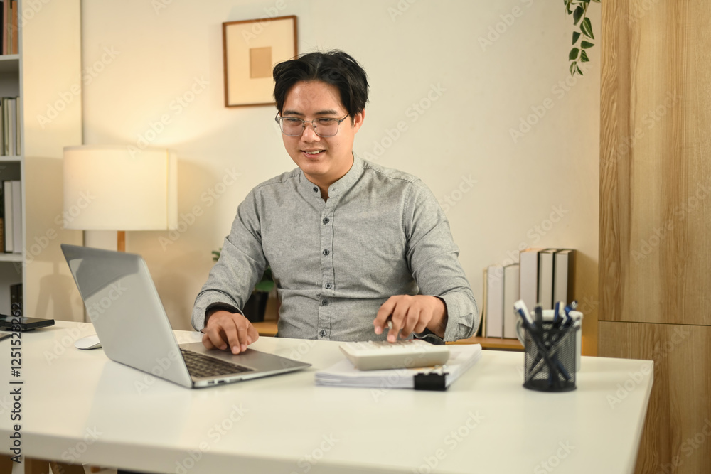 Obraz premium A professional accountant working on a laptop and calculator, reviewing financial documents in a modern office, symbolizing business analysis, financial planning, and corporate accounting