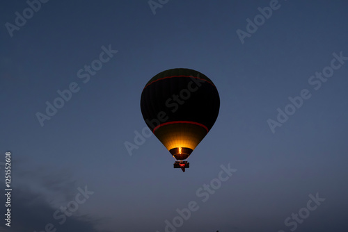 Hot air balloon is on the air at Cappadocia. Silhouette photo at sunrise.