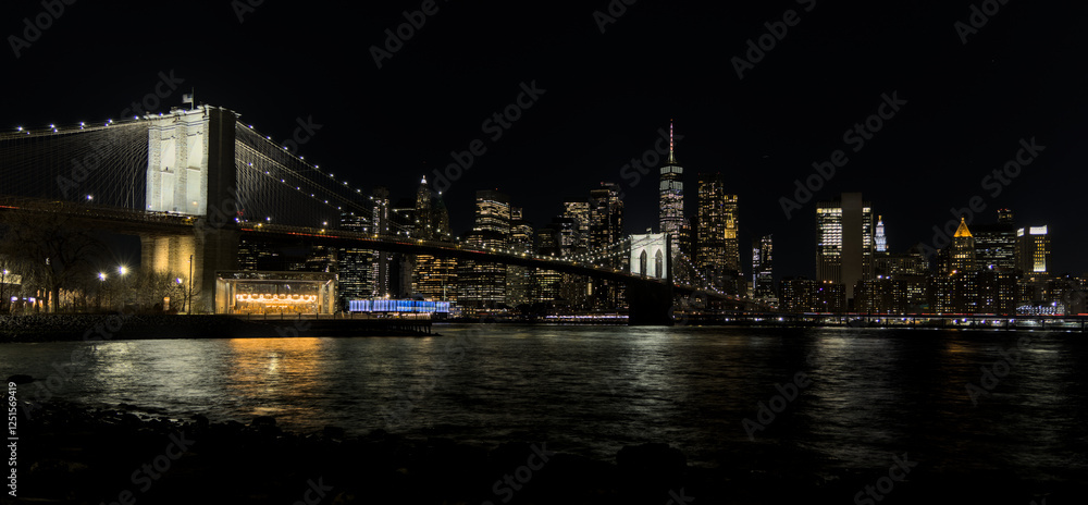 downtown manhattan new york city skyline with brooklyn bridge in the foreground at night (east river long exposure in dark darkness) lights office buildings skyscrapers travel tourism destination usa downtown manhattan new york city skyline with brooklyn bridge in the foreground at night (east river long exposure in dark darkness) lights office buildings skyscrapers travel tourism destination usa