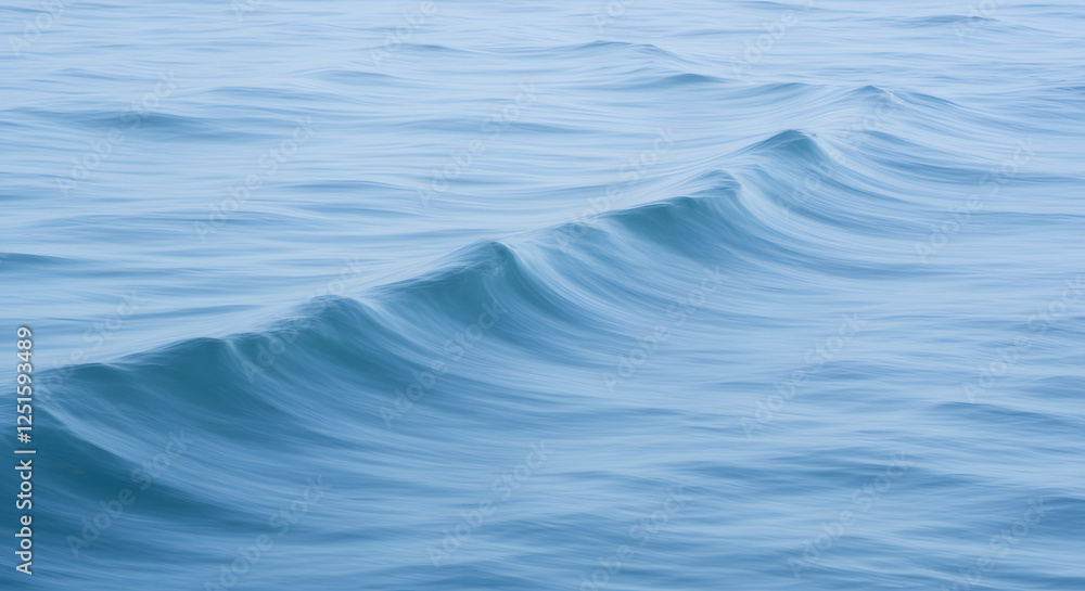 Naklejka premium Gentle Wave Rolling on Open Water With Smooth Blue Texture