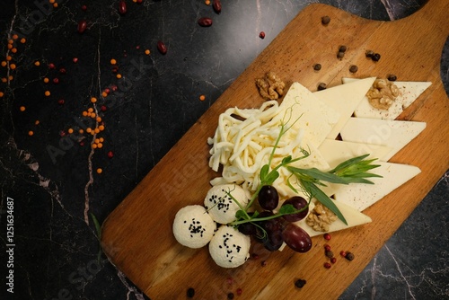 Fotografie Creative Cheese Arrangement on Wooden Serving Board, High Angle View