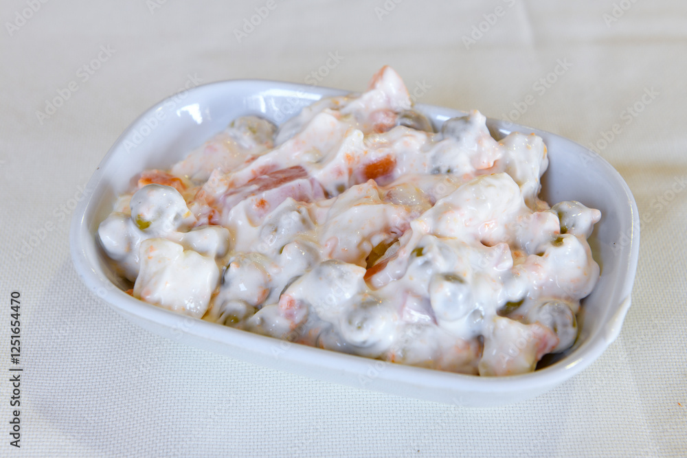 Bowl of russian salad olivier with meat and vegetables on a table Bowl of russian salad olivier with meat and vegetables on a table