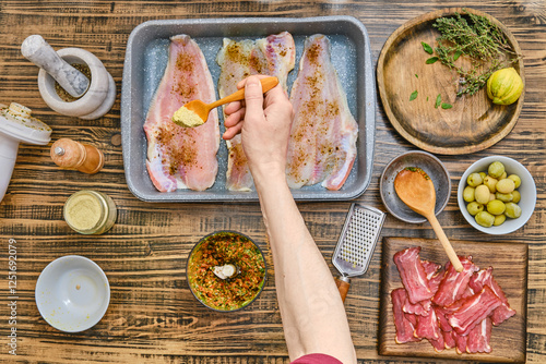 Preparing a flavorful dish with fresh fish and herbs in a cozy kitchen setting