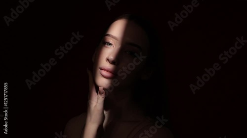 Portrait of attractive girl with healthy clean skin and beautiful make-up. The girl shows her well-groomed skin on her face and neck. Aesthetic cosmetology and makeup concept.