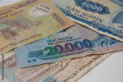 Assortment of Vitenamese dong bank notes over a desk photo