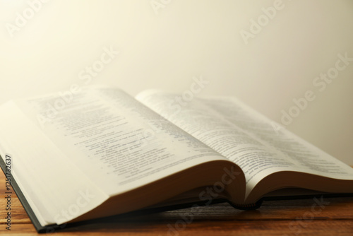 Open Holy Bible in English language on wooden table, closeup photo