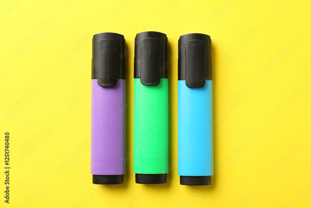 Bright highlighters on yellow background, flat lay Bright highlighters on yellow background, flat lay