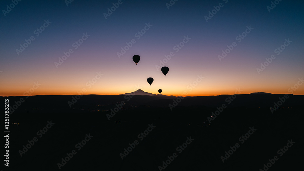 Cappadocia with colorful hot air balloons flying in the sky over deep canyons . Cappadocia with colorful hot air balloons flying in the sky over deep canyons .