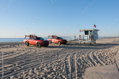 Lifeguard tower/hut and lifeguard pickup trucks on Redondo Beach (Torrance district) in Los Angeles with a bright blue sky