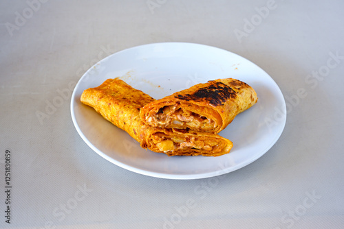 Lavash doner kebab ( soslu kasarli zurna doner durum )  or shawarma sliced in plate isolated.  Tavuk Et Doner Durum. Hatay Iskenderun usulu bazuka tavuk doner durum.  photo