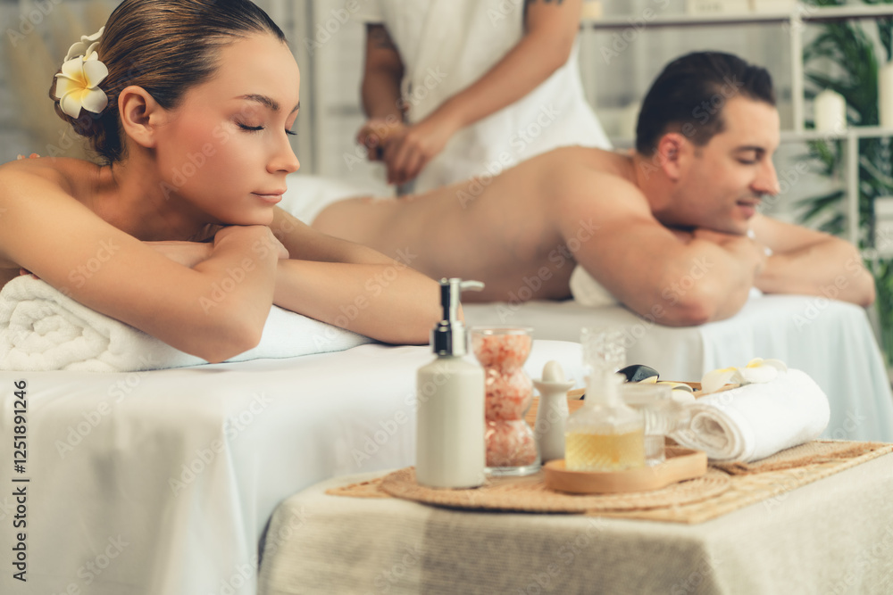 Caucasian couple customer enjoying relaxing anti-stress spa massage and pampering with beauty skin recreation leisure in day light ambient salon spa at luxury resort or hotel. Quiescent Caucasian couple customer enjoying relaxing anti-stress spa massage and pampering with beauty skin recreation leisure in day light ambient salon spa at luxury resort or hotel. Quiescent