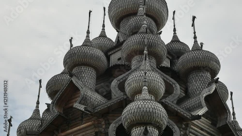 Kizhi Pogost. A historical site dating from the 17th century on Kizhi island. Russian wooden churches stand on a small island. Sunny weather. People walking are visible.