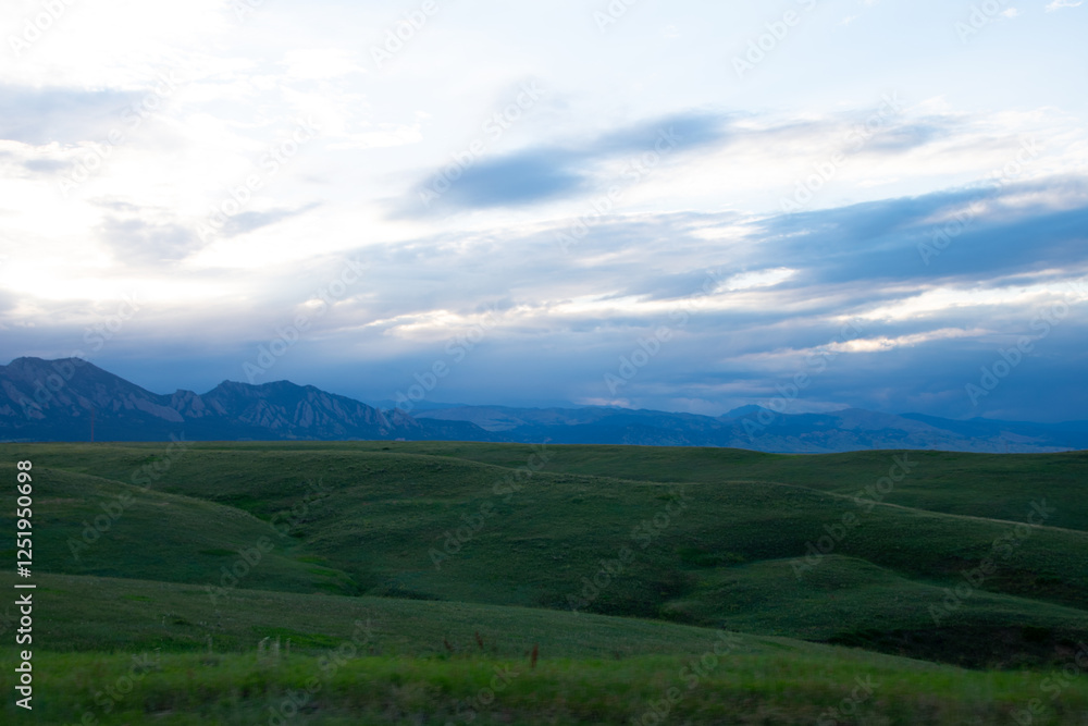 Green rolling hills with mountains in the distance Green rolling hills with mountains in the distance