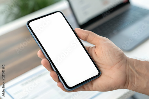 Person Holding Mobile Phone With Empty Display In Office Workspace