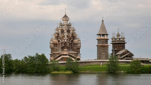 Kizhi Pogost. A historical site dating from the 17th century on Kizhi island. Russian wooden churches stand on a small island. Sunny weather. People walking are visible.