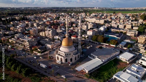 Aerial view of a city with residential buildings surrounding the Al Rawda Mosque photo