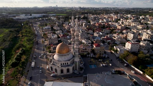 Aerial view of a city with residential buildings surrounding the Al Rawda Mosque photo