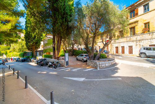 Fototapeta Naklejka Na Ścianę i Meble -  Cars park along the hillside streets outside the walled medieval old town of Saint Paul de Vence, France.