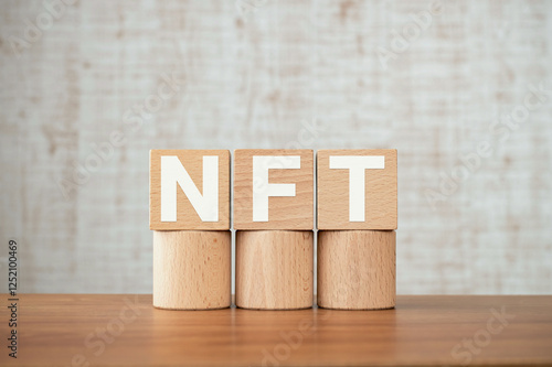 There is wood cube with the word NFT. It is an abbreviation for Non-Fungible Token as eye-catching image. photo