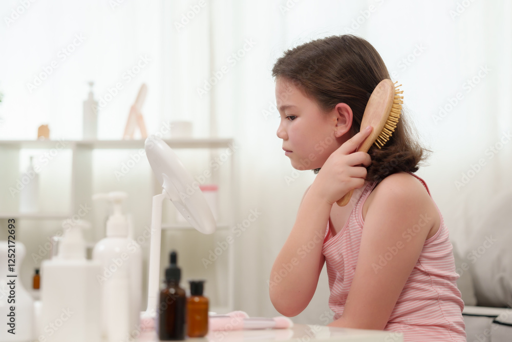Caucasian girl learning makeup. A young girl gazes at herself in the mirror while holding a makeup brush. The setting reflects innocence, self-care, and early exploration of beauty. Caucasian girl learning makeup. A young girl gazes at herself in the mirror while holding a makeup brush. The setting reflects innocence, self-care, and early exploration of beauty.