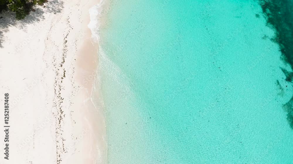 Aerial view of a beach showcasing pristine white sand gently meeting clear turquoise waters. Praslin, Seychelles. Aerial view of a beach showcasing pristine white sand gently meeting clear turquoise waters. Praslin, Seychelles.