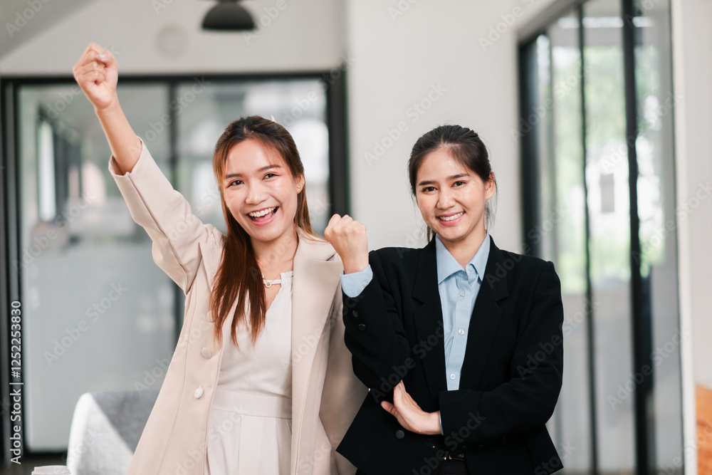Two professional women in business attire celebrating a successful achievement in a bright, modern office space. Two professional women in business attire celebrating a successful achievement in a bright, modern office space.